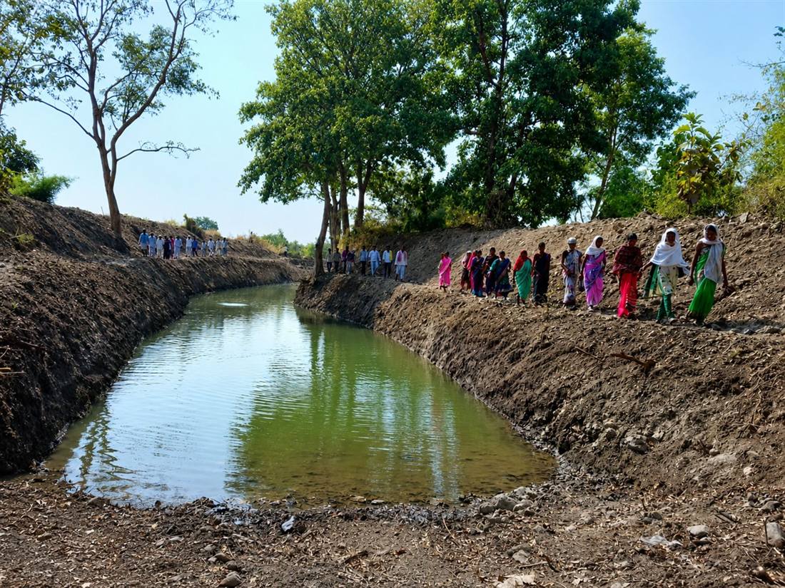 Villagers lined along a completed Doha structure filled with monsoon water
