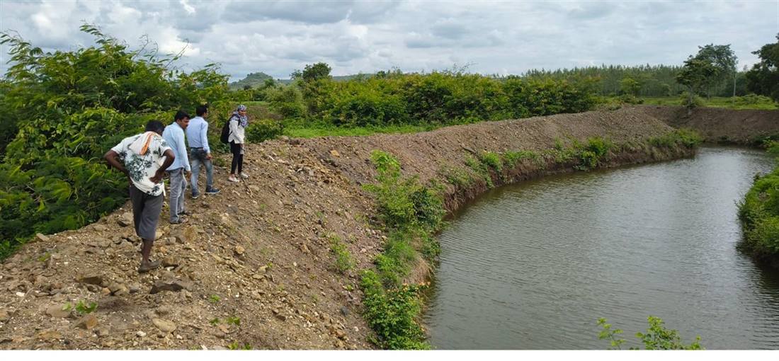 A village gathering beside a water conservation structure